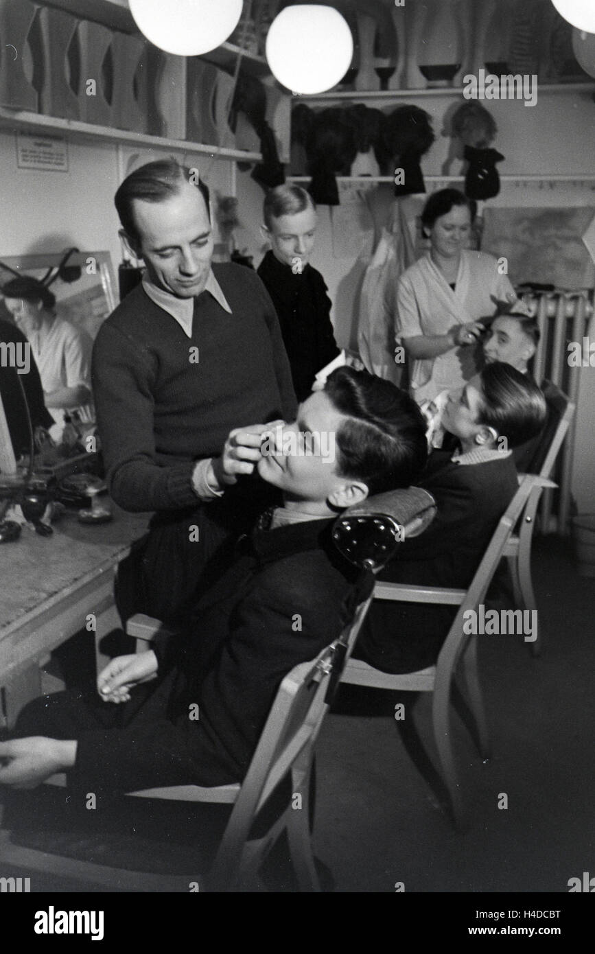 Schauspieler werden für die Probeaufnahmen für den Film Familienanschluss von Carl Boese geschminkt; Deutschland ca. 1940. Actors getting make-up for the audition for the film Familienanschluss by Carl Boese; Germany ca. 1940. Stock Photo