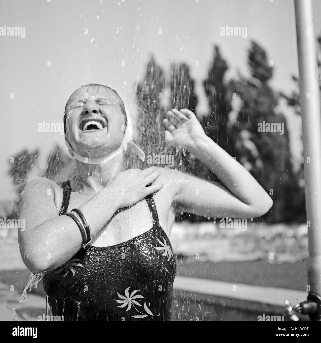 Eine Frau kühlt sich ab an einer Dusche in Bad Rippoldsau Schapbach im Schwarzwald, Deutschland 1930er Jahre. A woman cooling herself in a shower at Bad Rippoldsau Schapbach in Black Forest, Germany 1930s. Stock Photo