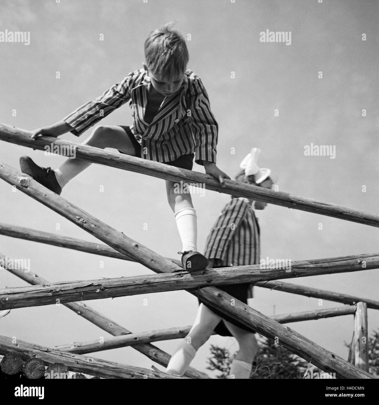 Kinder spielen und klettern auf einem Holzgerüst in Deutschland, 1930er Jahre. Children playing and climbing on a woodden framework, Germany 1930s. Stock Photo