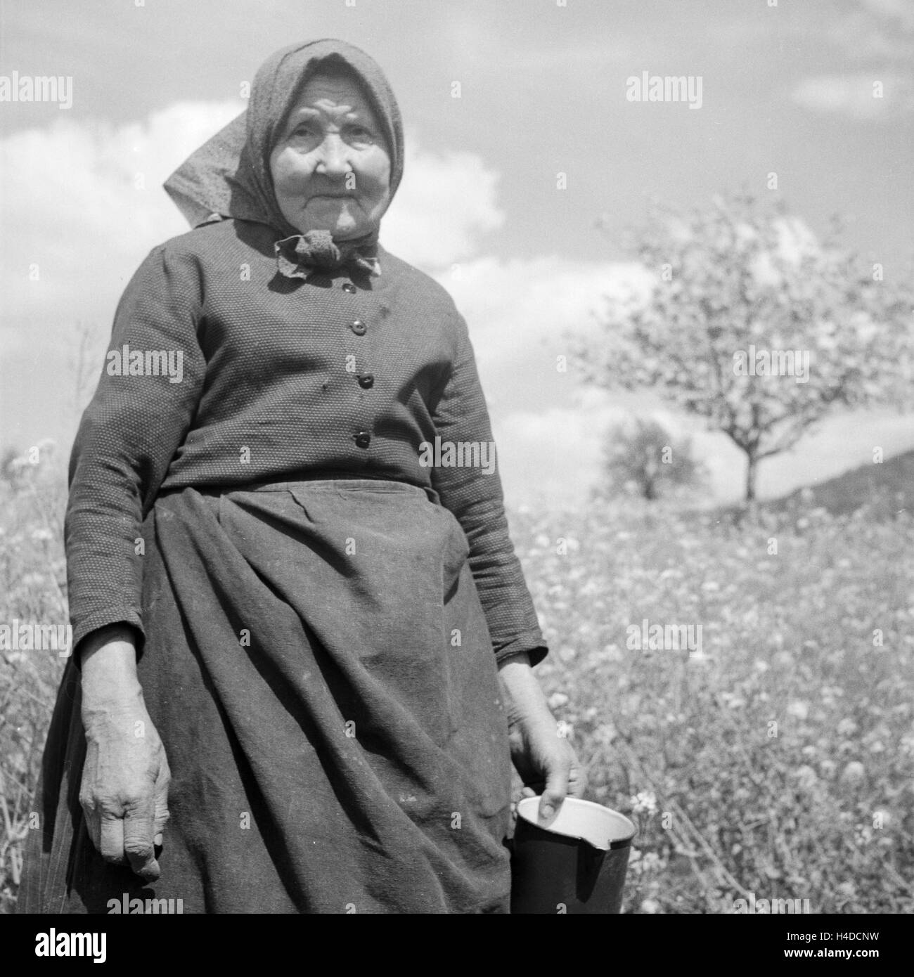 Ältere Landfrau mit einem Milchkrug, Deutschland 1930er Jahre. Elder landlady with a milk jug, Germany 1930s. Stock Photo