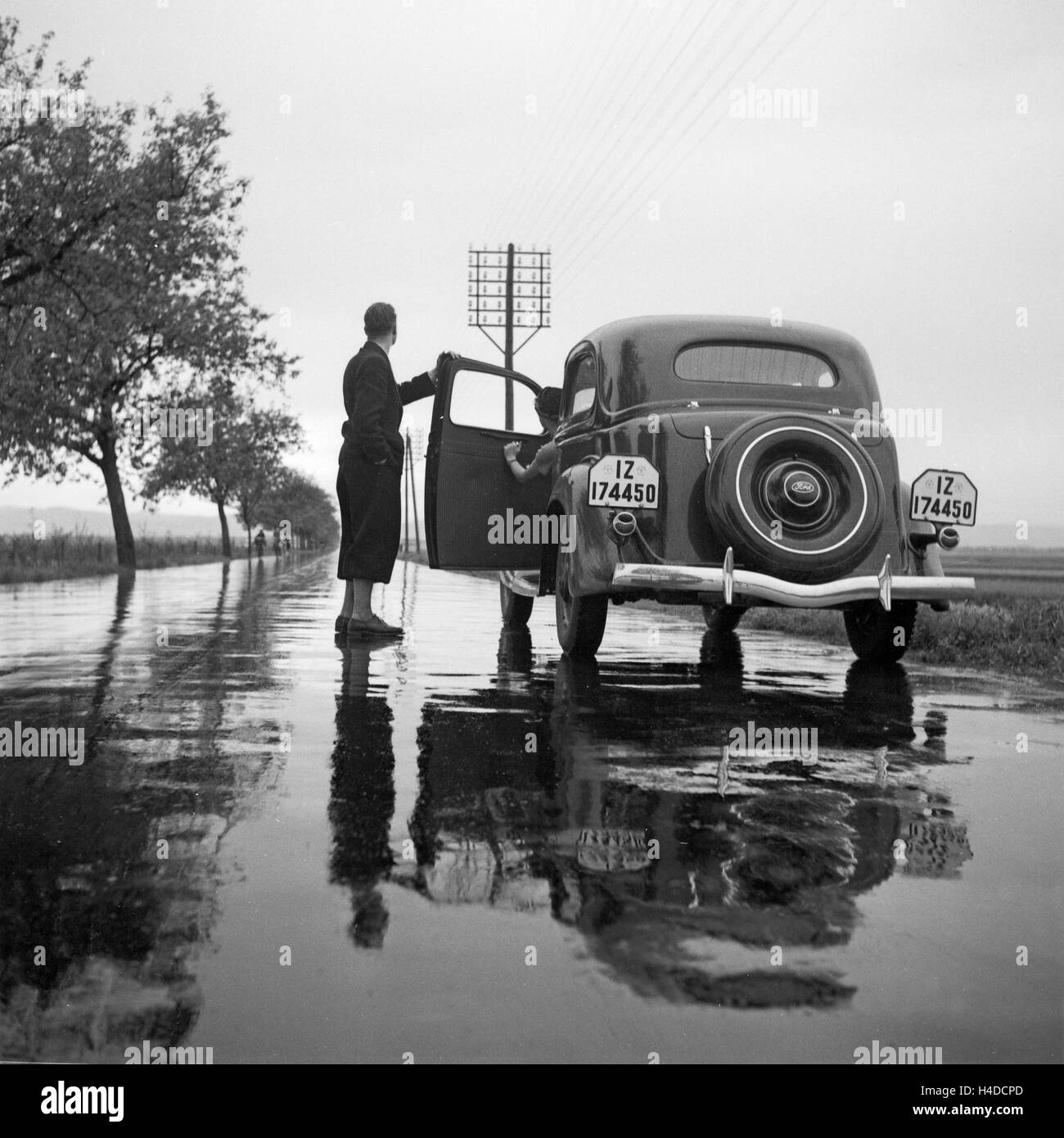 Mit dem Ford V8 auf regennasser Fahrbahn, Deutschland 1930er Jahre. With the Ford V8 on a wet street, Germany 1930s. Stock Photo