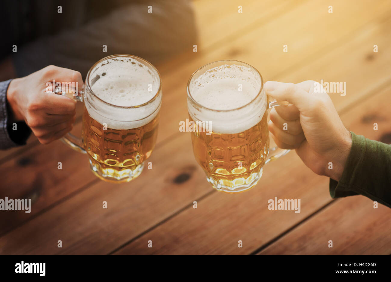 close up of hands with beer mugs at bar or pub Stock Photo