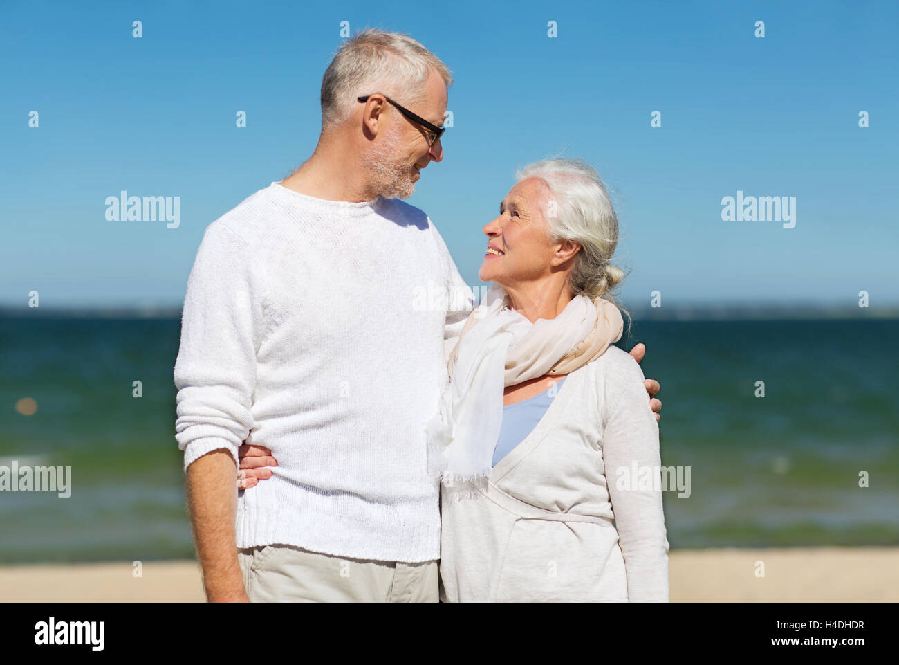 happy senior couple hugging on summer beach Stock Photo