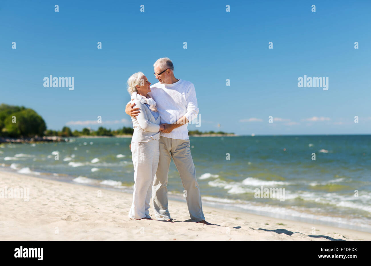 happy senior couple holding hands on summer beach Stock Photo - Alamy