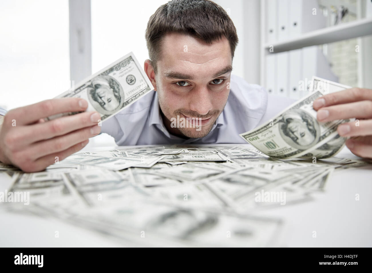happy businessman with heap of money in office Stock Photo - Alamy