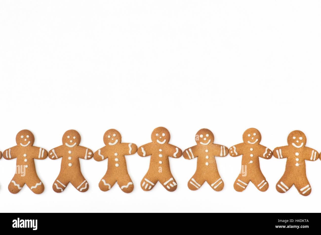 Gingerbread Men biscuits in a line on a white background Stock Photo