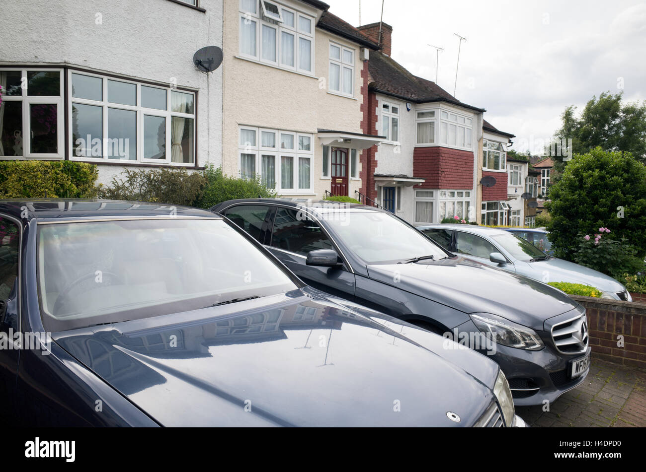 Cars parked on the front drive of houses in Barnet, North London, England, UK Stock Photo