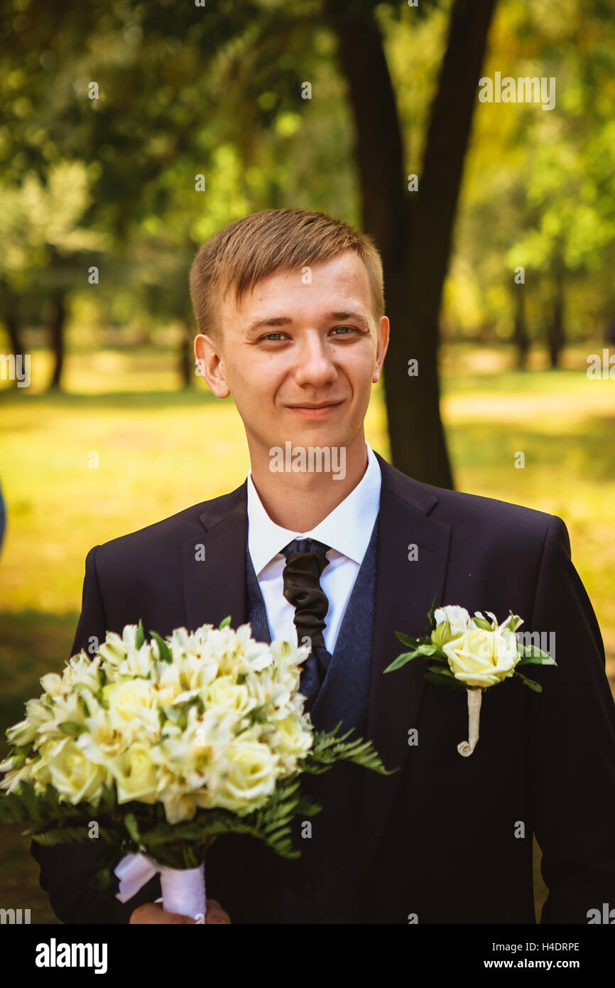 portrait of a young groom standing near park Stock Photo - Alamy