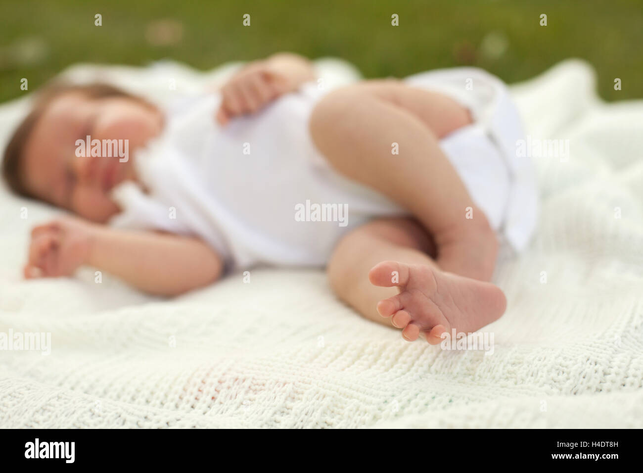 Baby sleeping on the grass Stock Photo