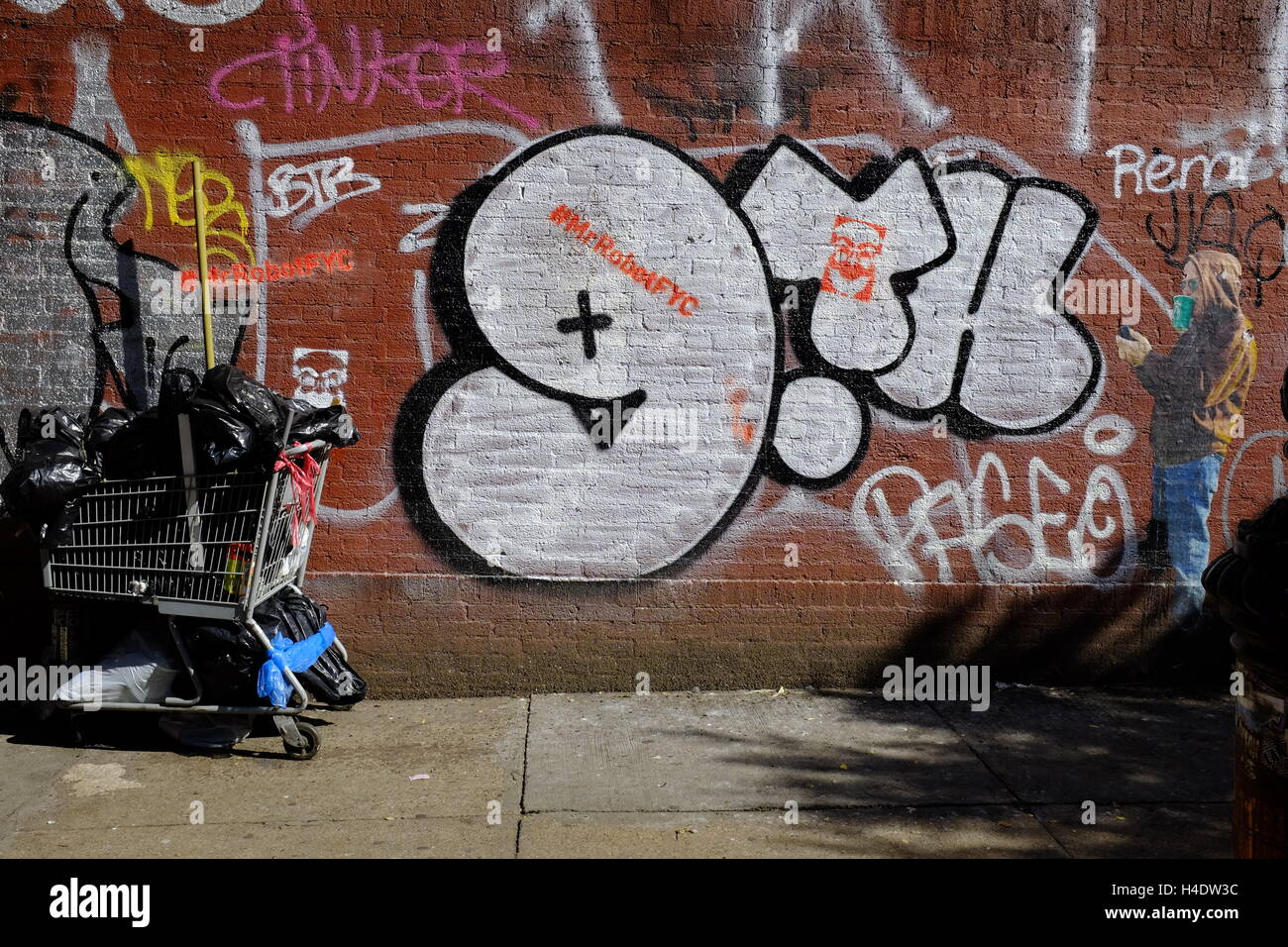 Graffiti on the sidewalk wall near East Broadway in