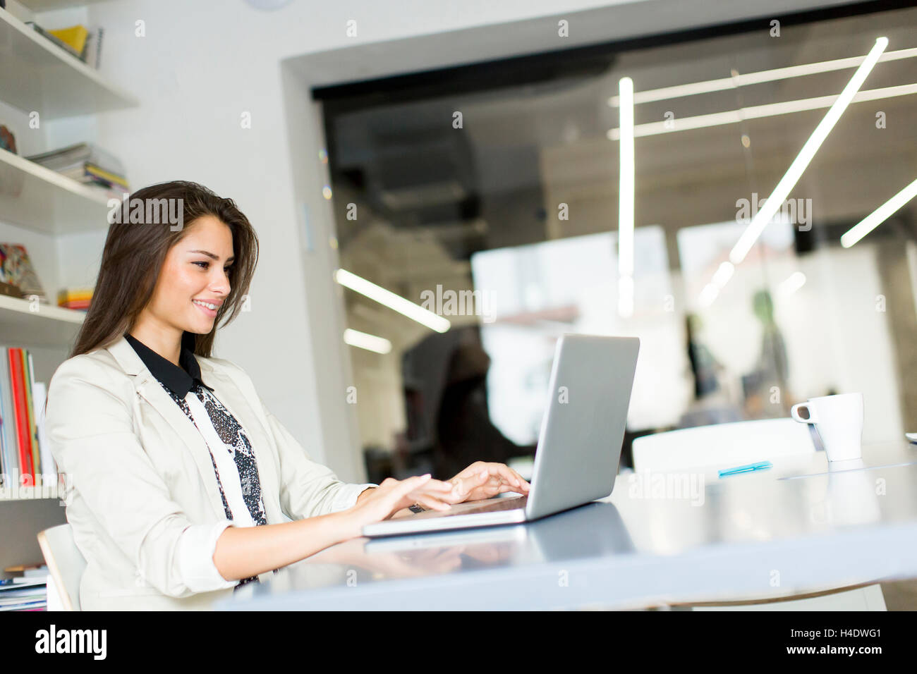 Pretty young woman working on laptop in the office Stock Photo - Alamy