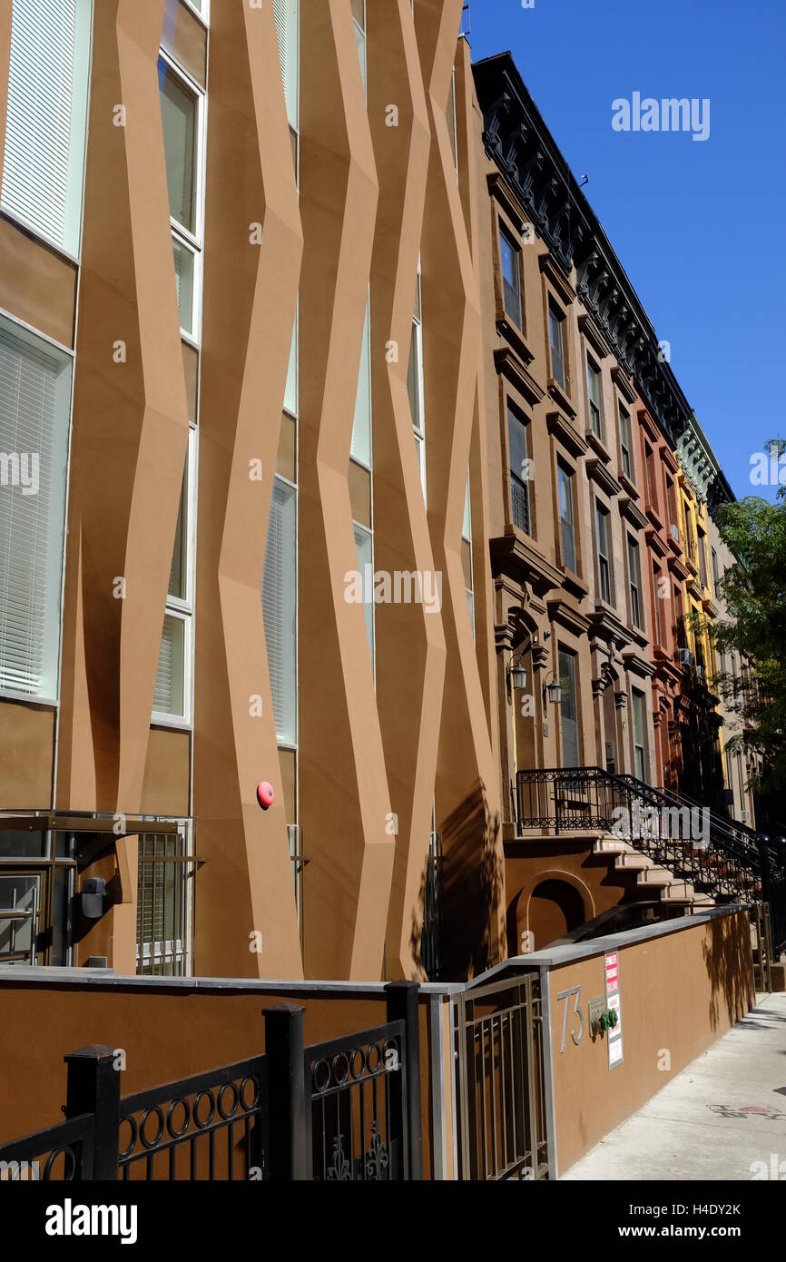 A newly built house among renovated classic brownstone apartment buildings.Harlem,Manhattan.New