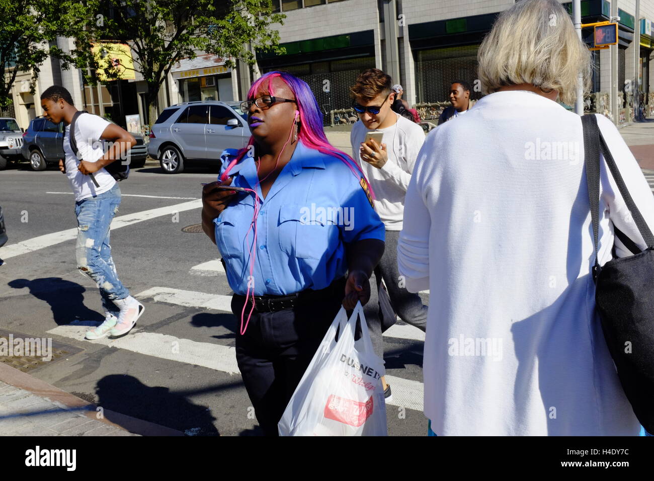 An African-American lady with dyed pink and blue hair on street of Harlem.Manhattan,New York City,USA Stock Photo
