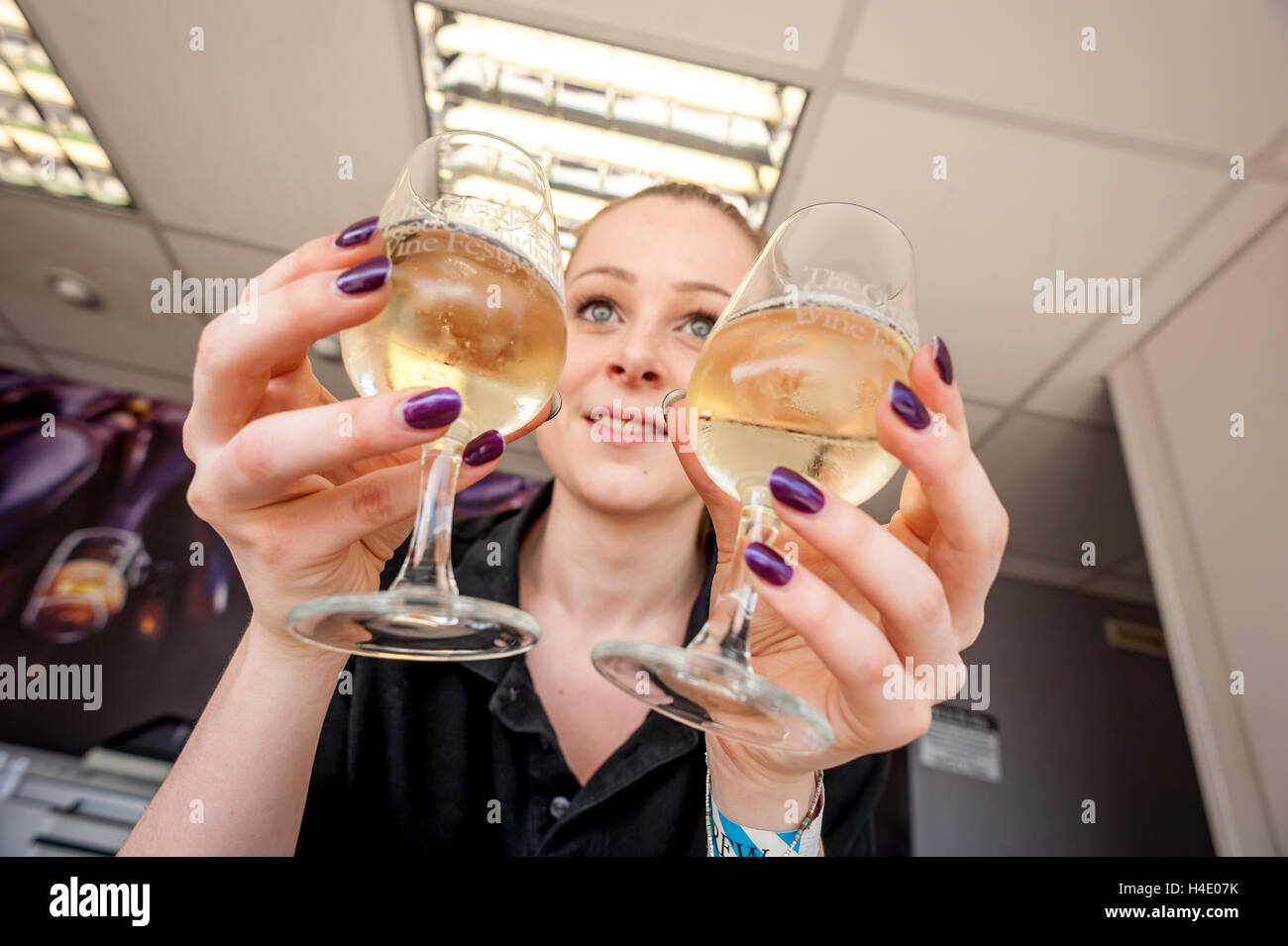 24-year-old Katie Dowding, from the Sparkling English Wine company pouring glasses of sparkling wine at The Glynde Food and Engl Stock Photo