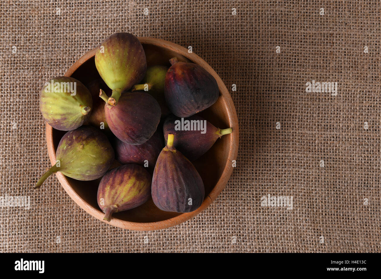 A wood bowl full of fresh picked figs. horizontal format with copy space. Stock Photo