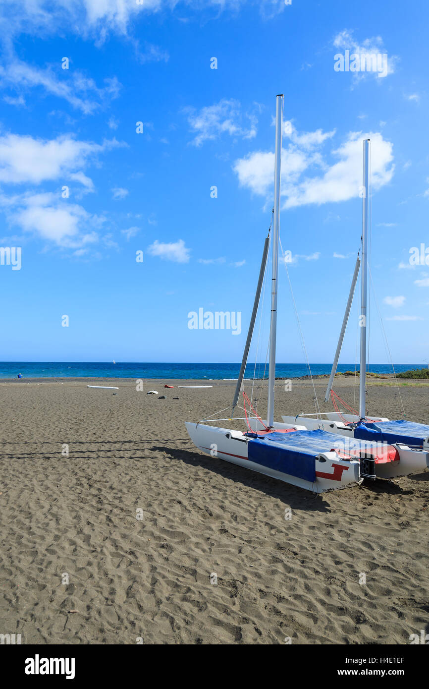 Catamaran boats on black sand volcanic beach in Las Playitas village, Fuerteventura, Canary Islands, Spain Stock Photo
