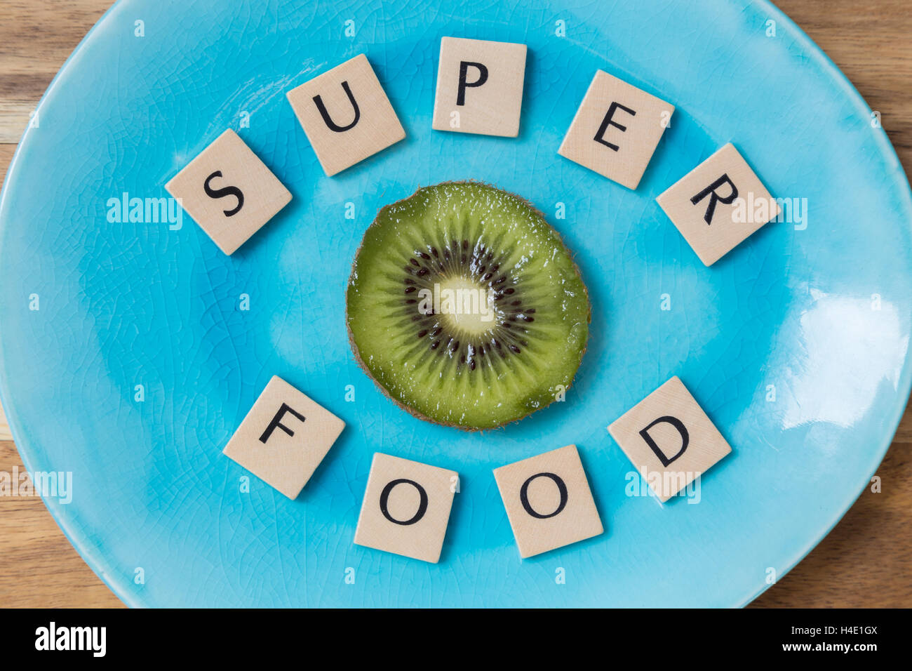 Superfood with kiwi on turquoise plate concept. Stock Photo