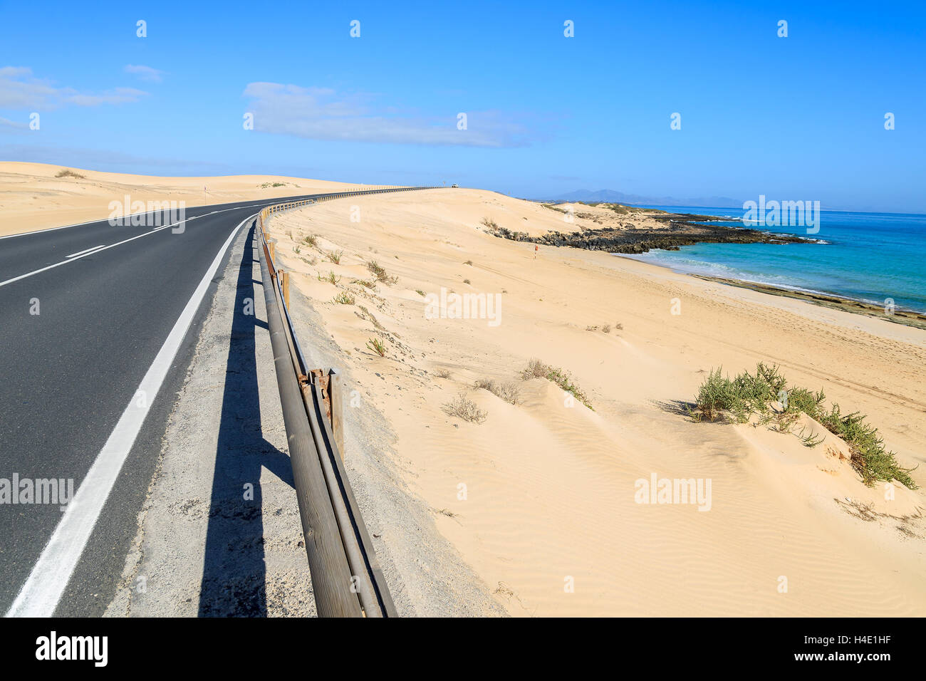 Sand dunes in Corralejo National Park and view of sea and road, Fuerteventura, Canary Islands, Spain Stock Photo