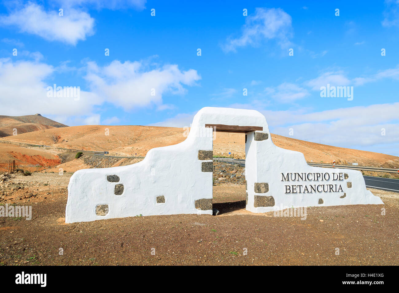 Traditionall municipality sign (white arch gate) near Betancuria village with desert landscape in the background, Fuerteventura, Canary Islands, Spain Stock Photo