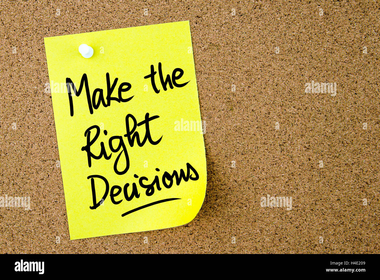 Make The Right Decisions text written on yellow paper note pinned on cork board with white thumbtack. Business concept image Stock Photo