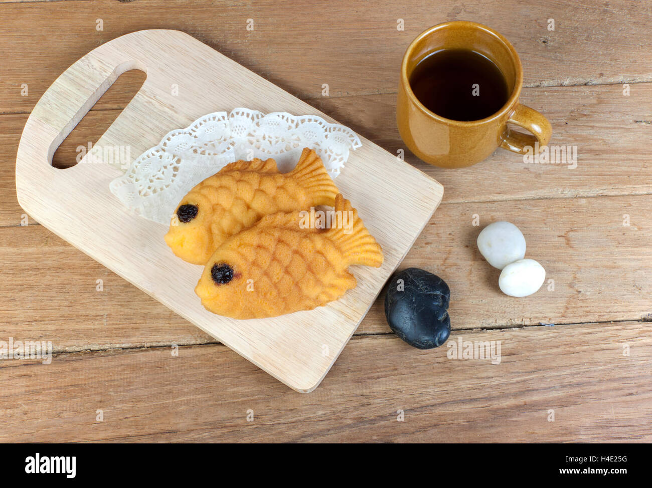 Taiyaki, japanese fish shaped pancake. Eaten with hot tea on wood table Stock Photo