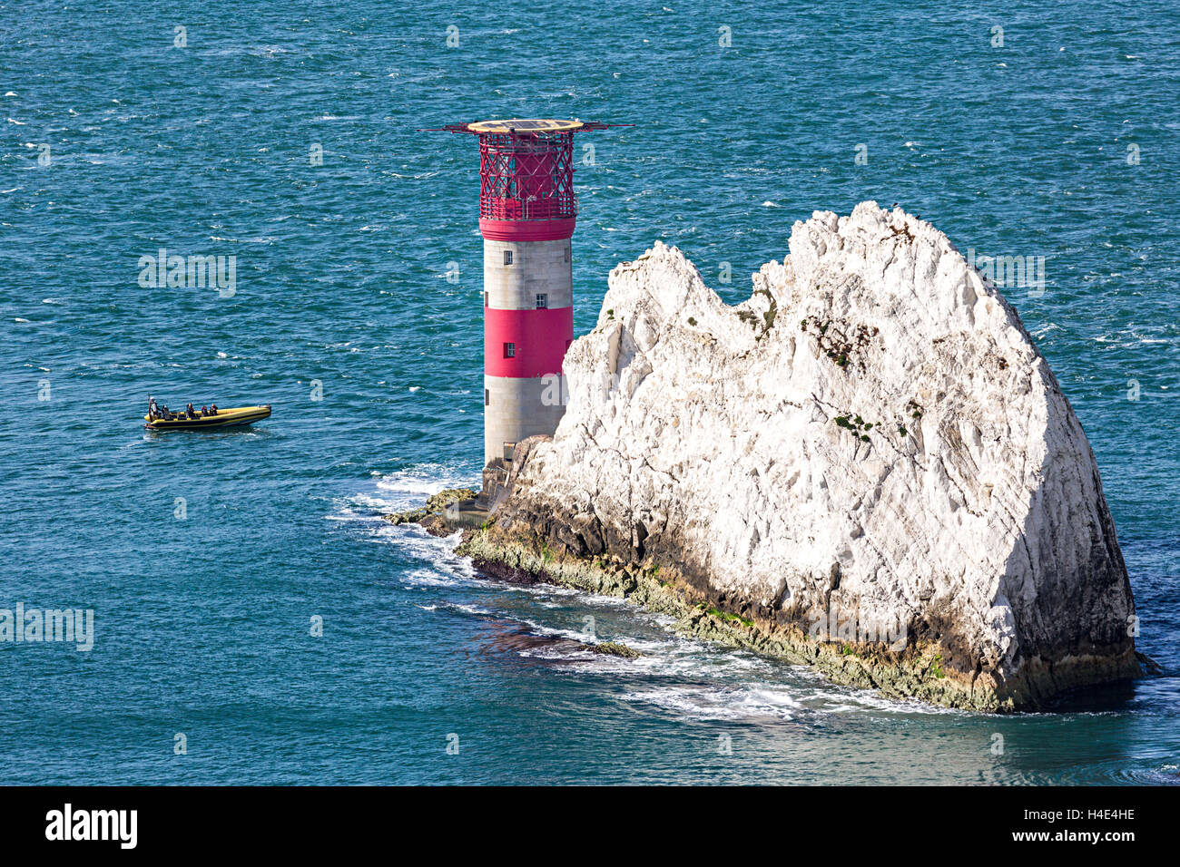 Boat rounding the lighthouse on the tip of the Needles, Isle of Wight, UK Stock Photo