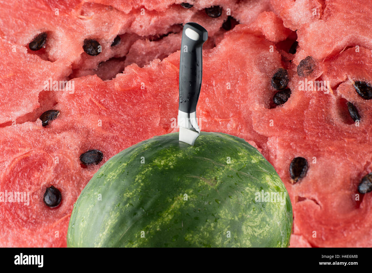 Riped watermelon with knife and red meat background Stock Photo - Alamy