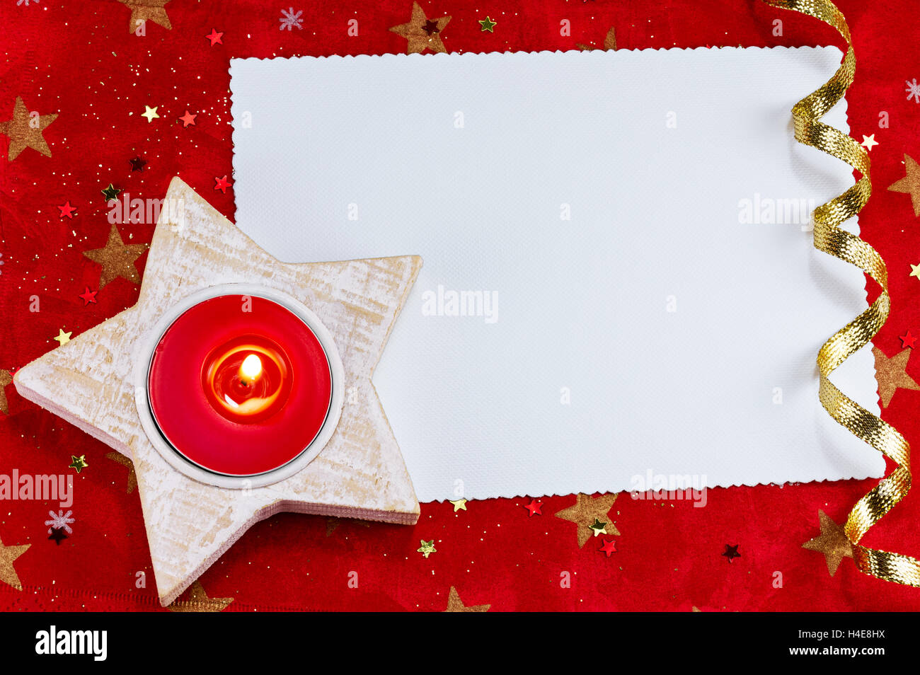 Greeting card with candle and ribbon against a red background Stock Photo
