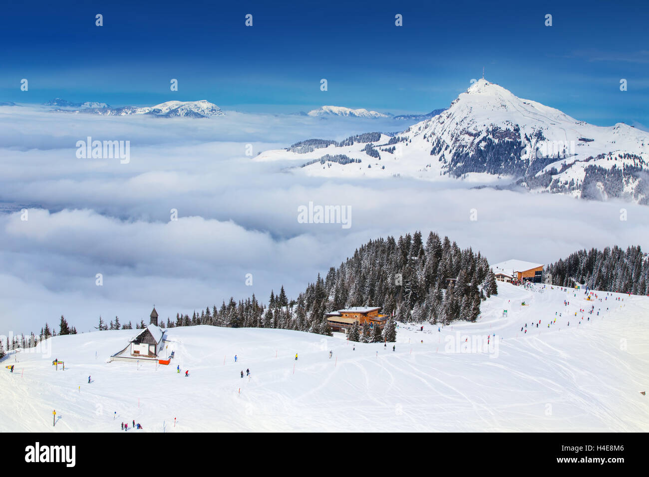 Skier skiing and enjoying the view to Tyrolian Alps in Austria from Kitzbuehel ski resort. Stock Photo