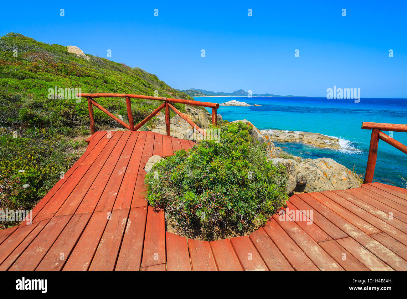 Red wooden viewpoint platform at Cala Sinzias bay and turquoise sea view, Sardinia island, Italy Stock Photo