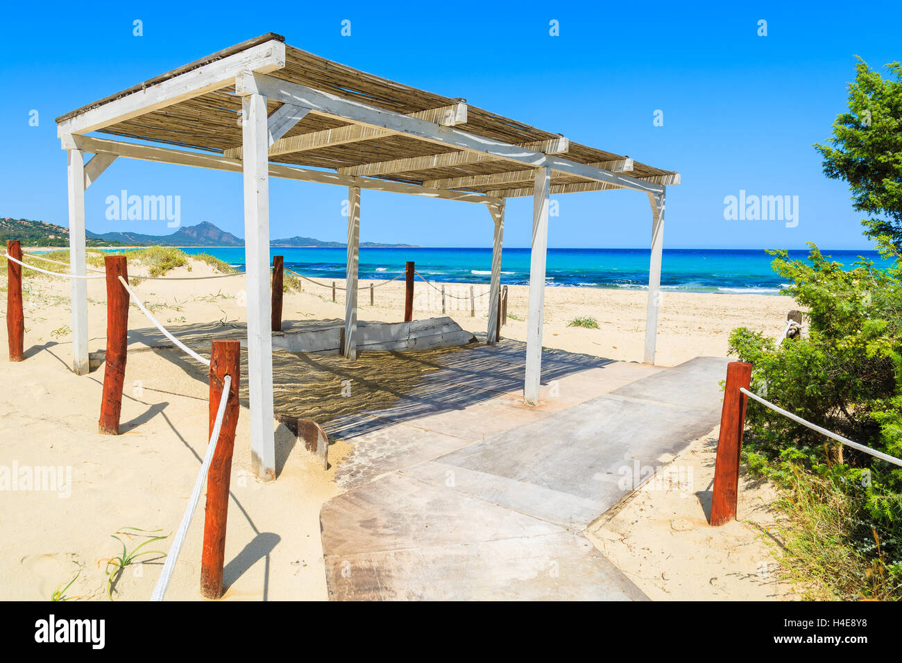 Wooden white sunshade construction and path to Costa Rei beach, Sardinia island, Italy Stock Photo