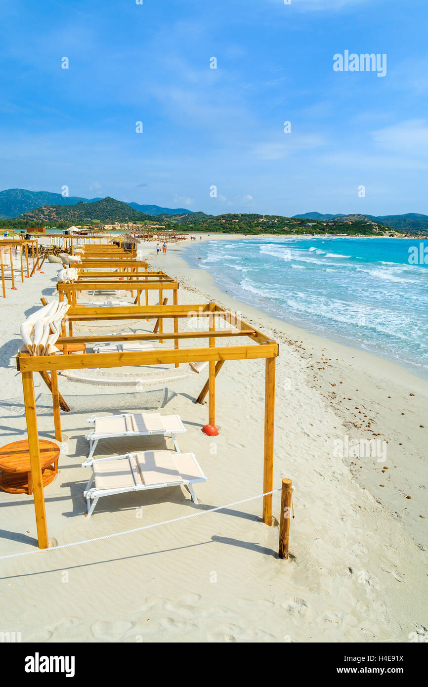 Sunchairs with wooden sunshade construction on white sand beach in Porto Giunco bay, Sardinia island, Italy Stock Photo