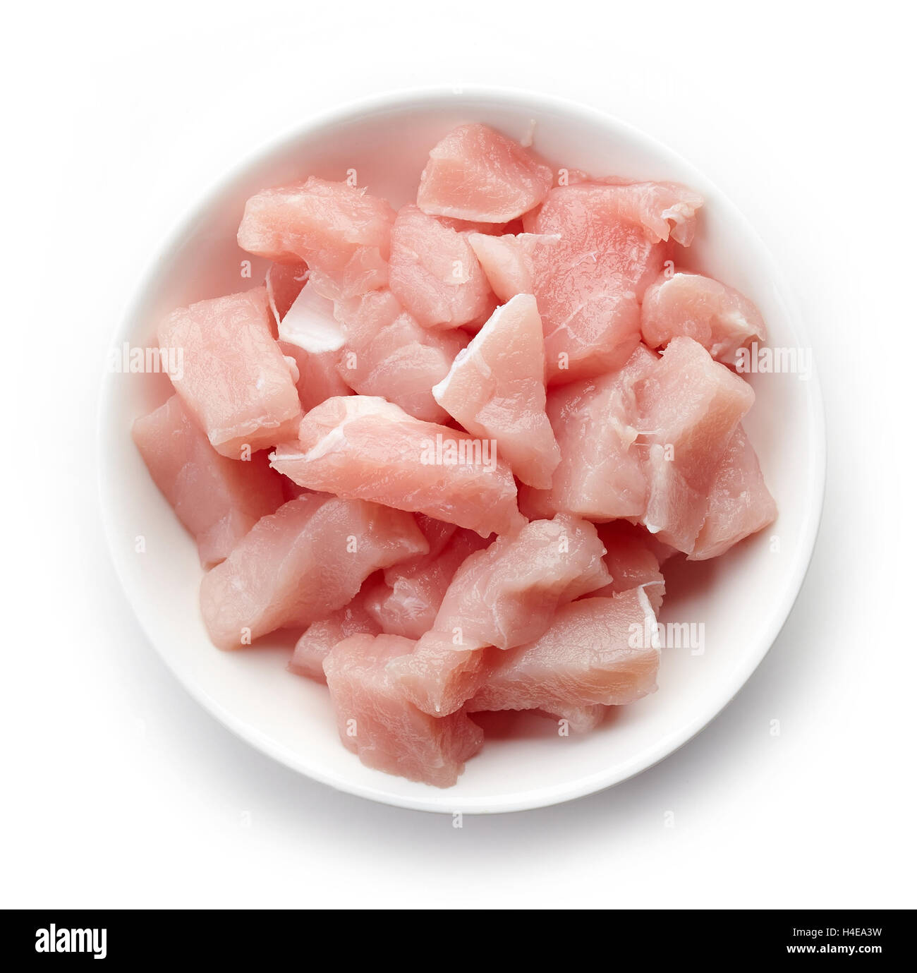 Raw cut meat chunks in white bowl isolated on white background, top view Stock Photo