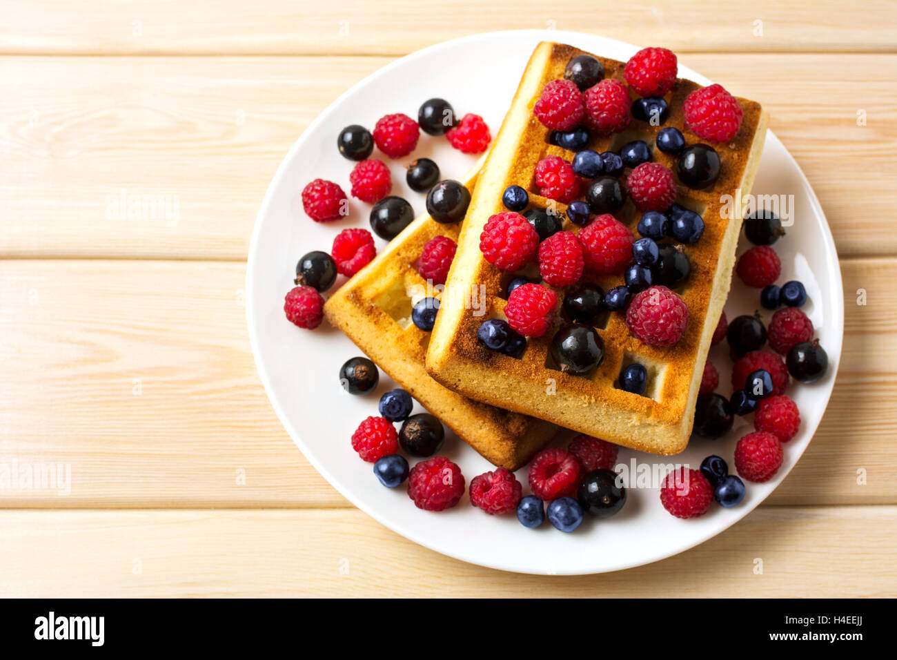 Soft waffle with fresh blueberry and raspberry top view. Breakfast soft waffles with fresh seasonal berries Stock Photo