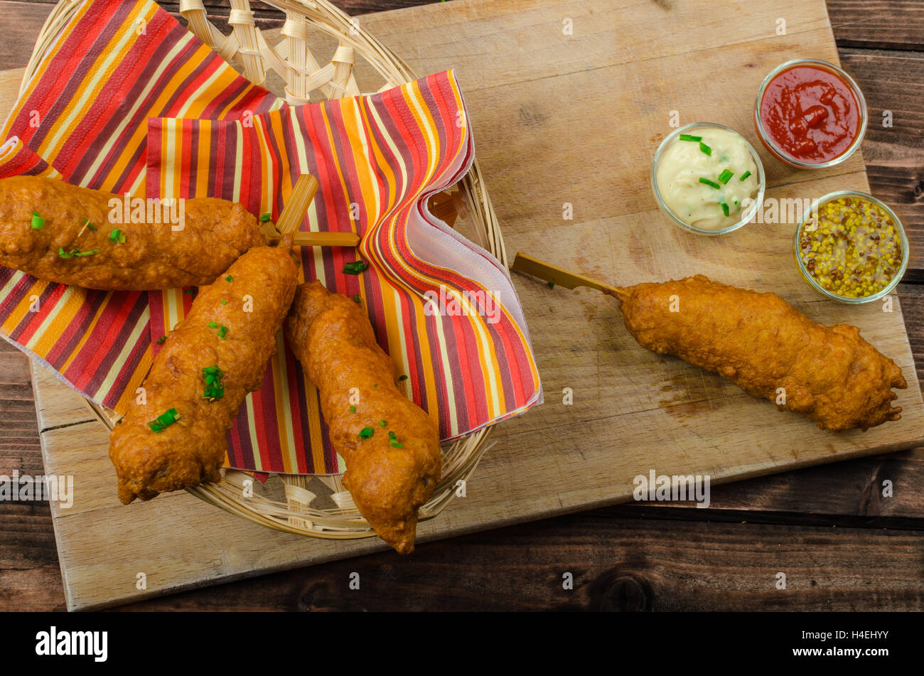 Corn dog with three sauces, chilli, mayonnaise with herbs and whole grained mustard Stock Photo