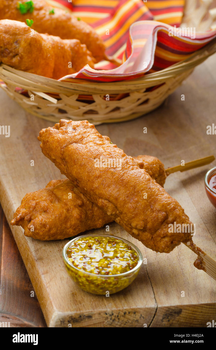 Corn dog with three sauces, chilli, mayonnaise with herbs and whole grained mustard Stock Photo