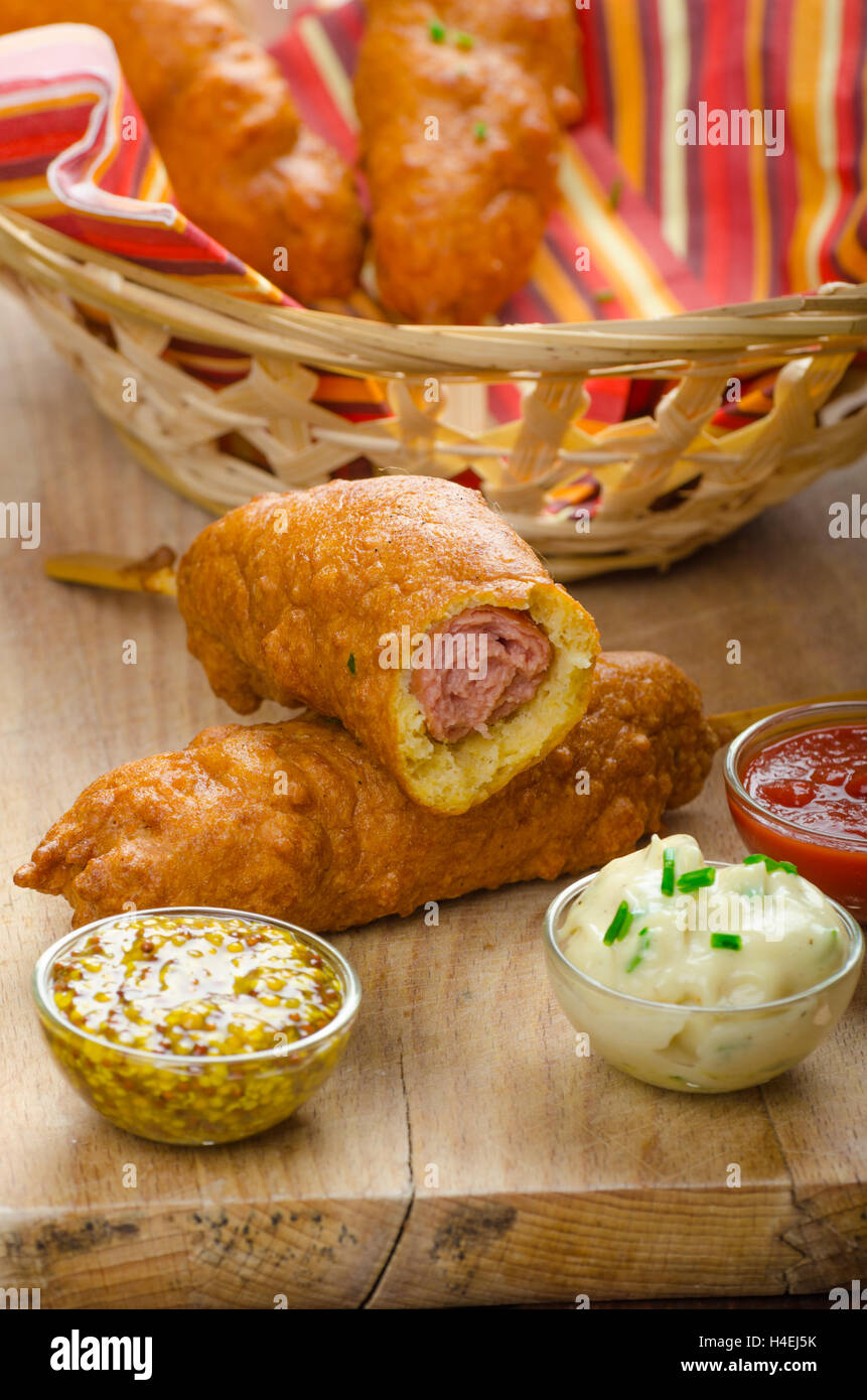 Corn dog with three sauces, chilli, mayonnaise with herbs and whole grained mustard Stock Photo