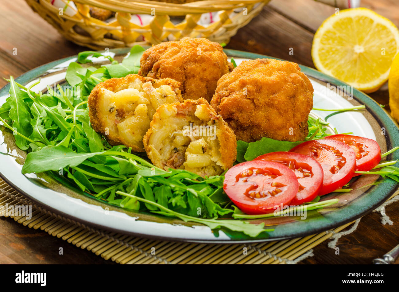 Macaroni and cheese balls, salad of arugula and healthy wholemeal bread