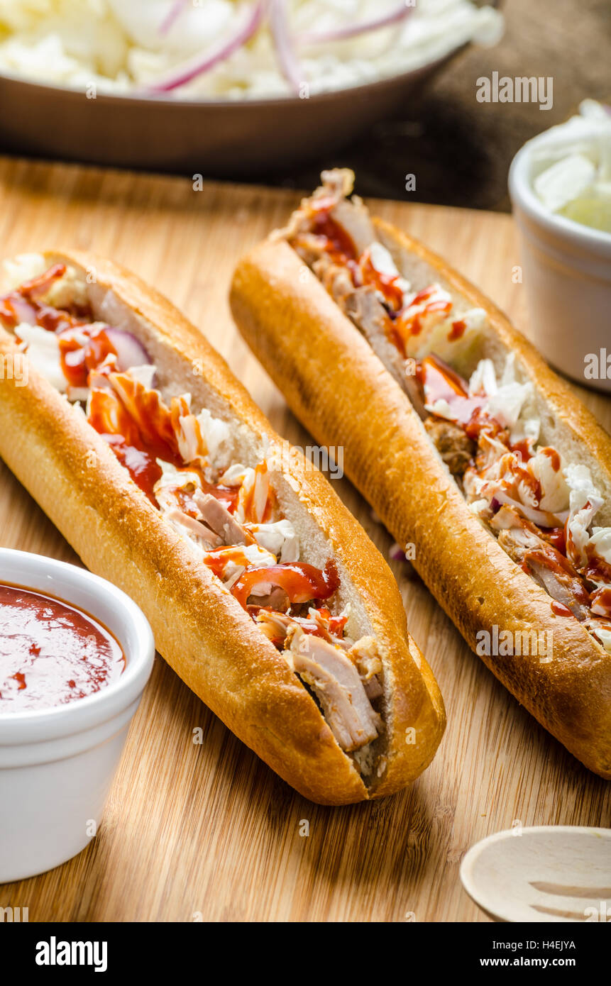 Pulled pork sandwich, long baked pork meat, pulled in fresh baquette with fresh salad and hot