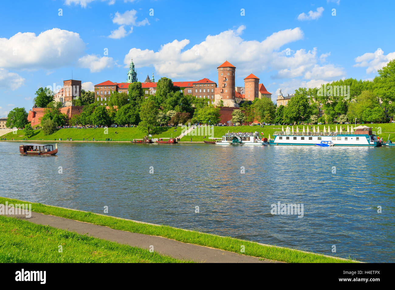 Tourist boats on Vistula river with Wawel Royal Castle in the background on sunny beautiful day, Poland Stock Photo