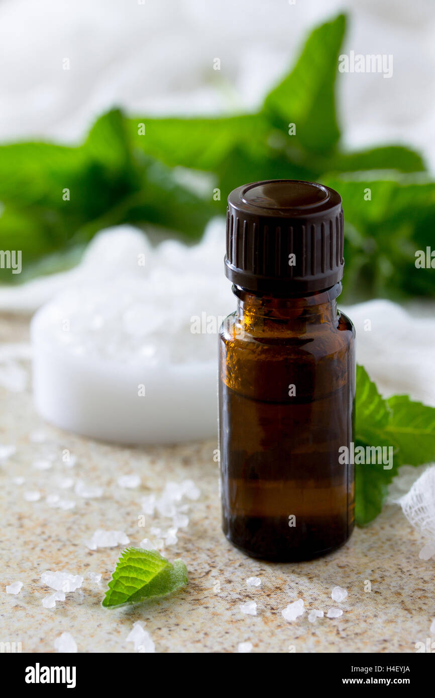 bottle of peppermint essential oil for aromatherapy on a brown stone background. Stock Photo