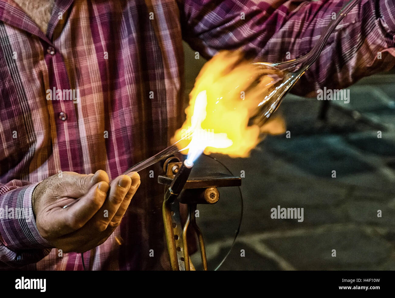 glassblower at work in the evening.grain effect added in post production Stock Photo