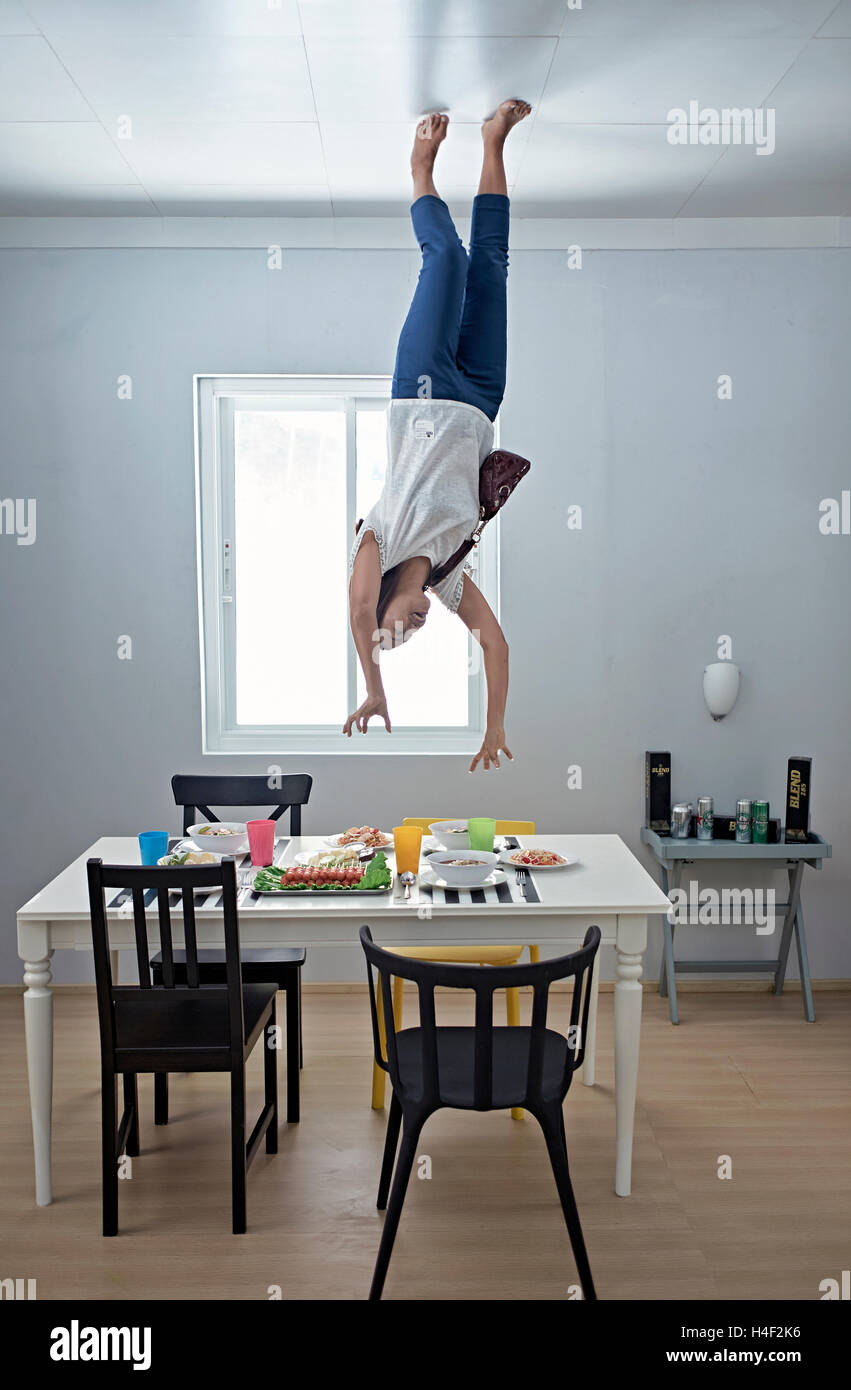 Woman having a fun time at the Upside-Down illusion house in Pattaya Thailand S. E. Asia Stock Photo