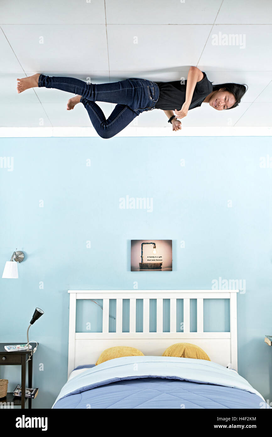 Teenage girl having a fun time at the Upside-Down illusion house in Pattaya Thailand S. E. Asia Stock Photo