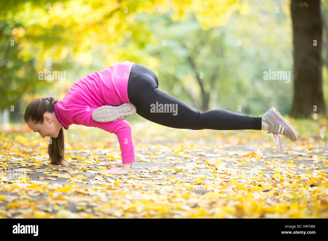 Autumn fitness outdoors: Eka Pada Galavasana pose Stock Photo - Alamy