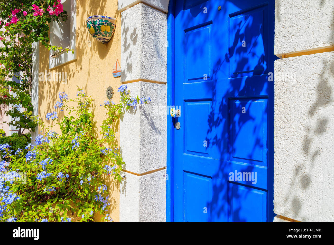 Blue door to greek house decorated with flowers in Assos village, Kefalonia island, Greece Stock Photo