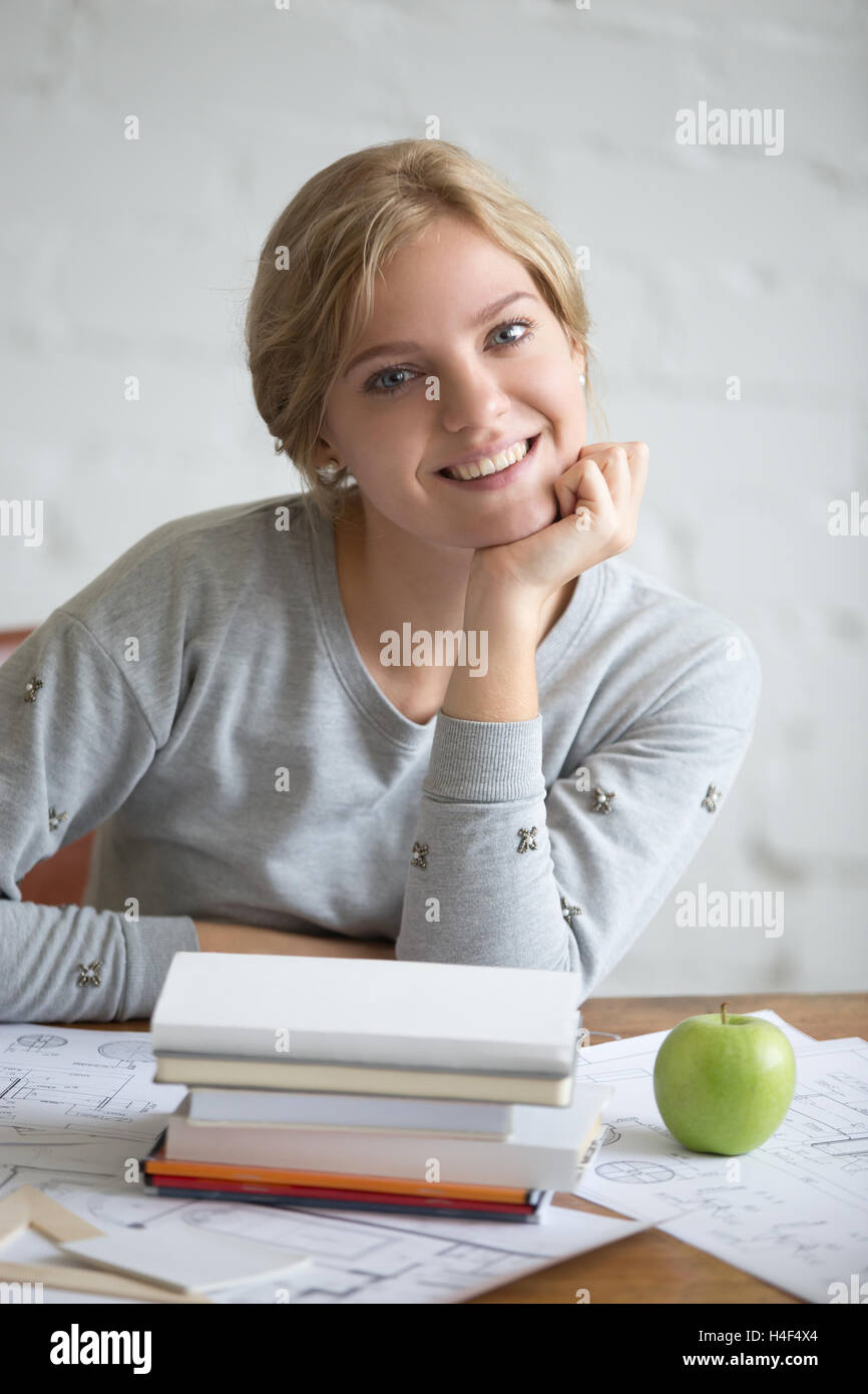 Portrait of a young smiling girl with books and apple Stock Photo - Alamy