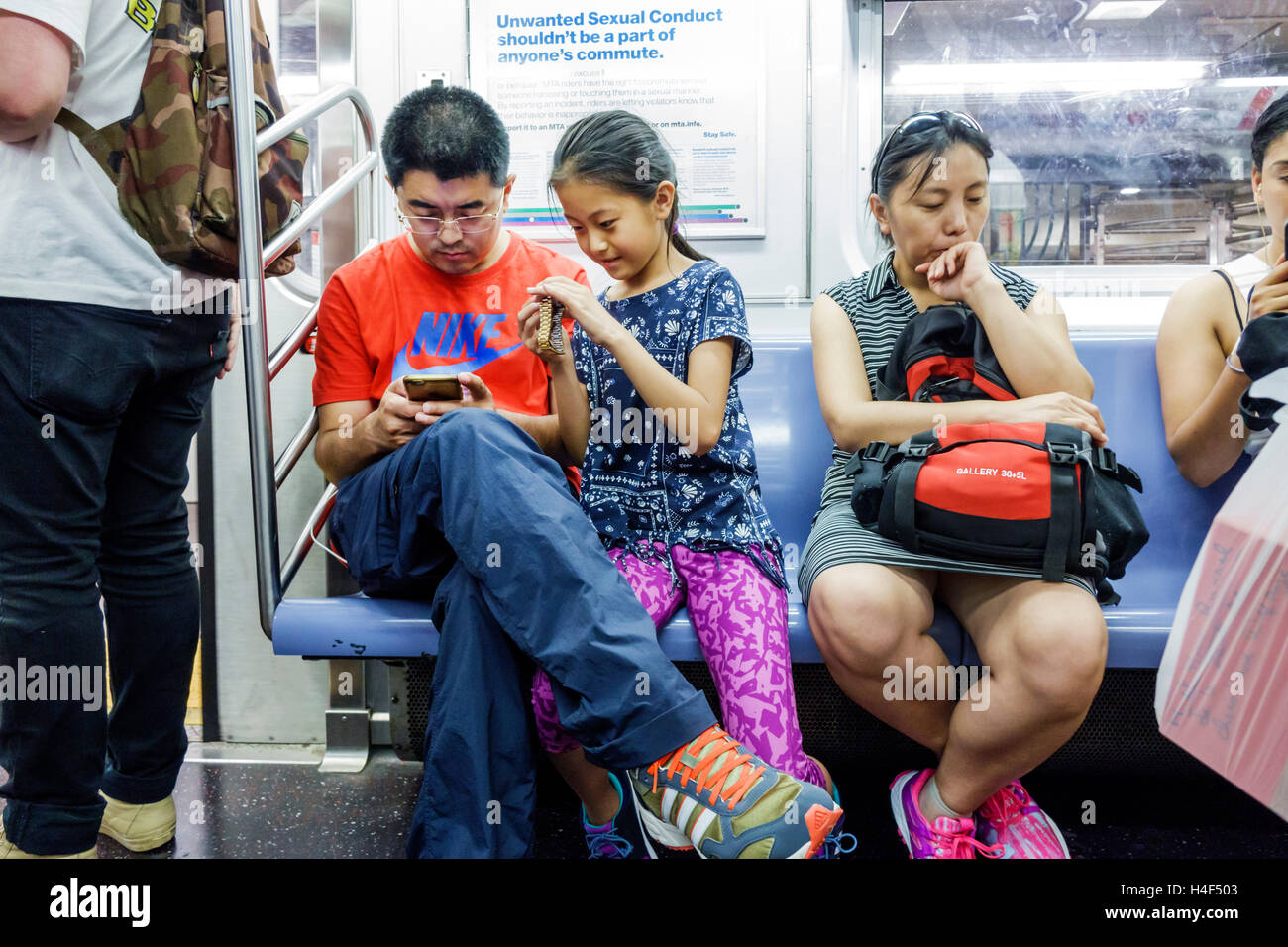 New York City,NY NYC,Queens,subway,train,MTA,public transportation,train,passenger passengers rider riders,sitting seated,Asian Asians ethnic immigran Stock Photo