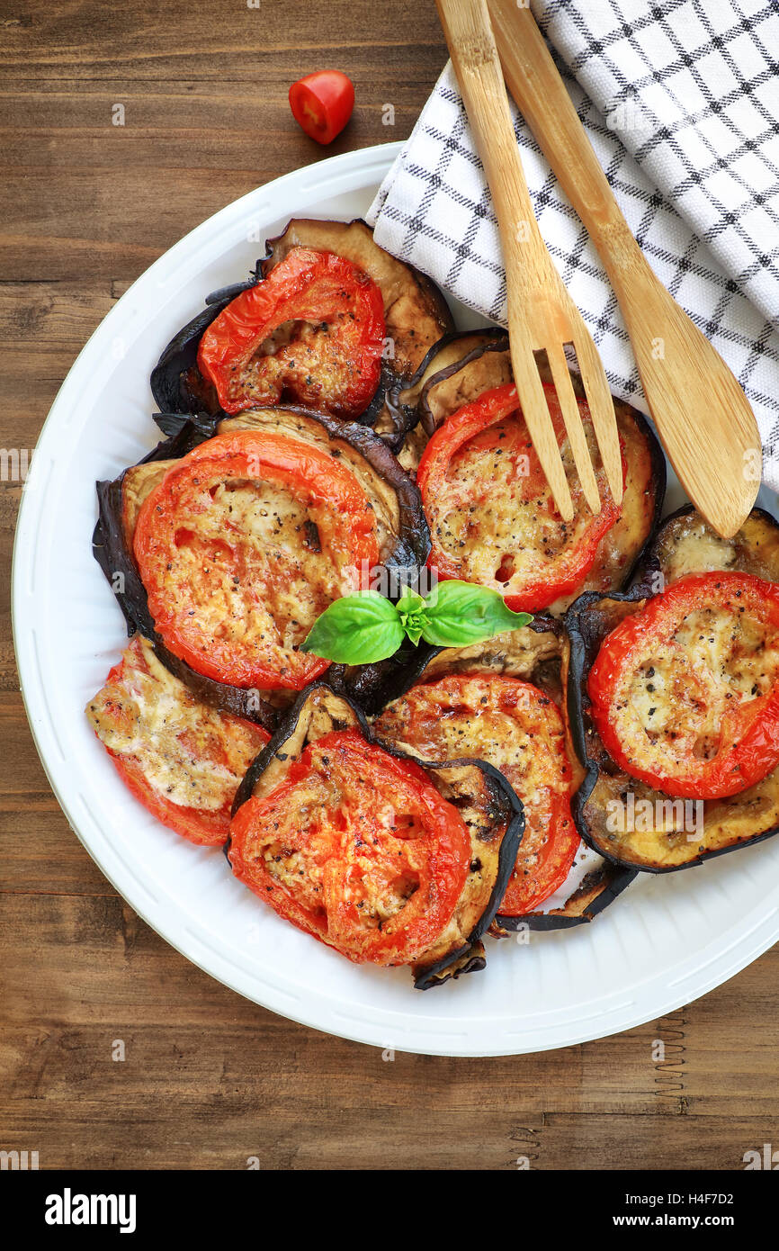 Baked eggplant with tomatoes as tasty vegetarian pizza topping, traditional italian food, organic nutrition Stock Photo