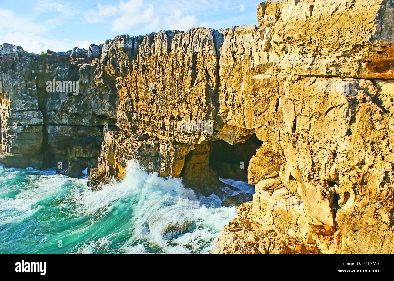 The cave in coastal rocks of Cascais is famous as the Boca do Inferno (The Jaws of Hell) or the Devil's Cave, Portugal. Stock Photo